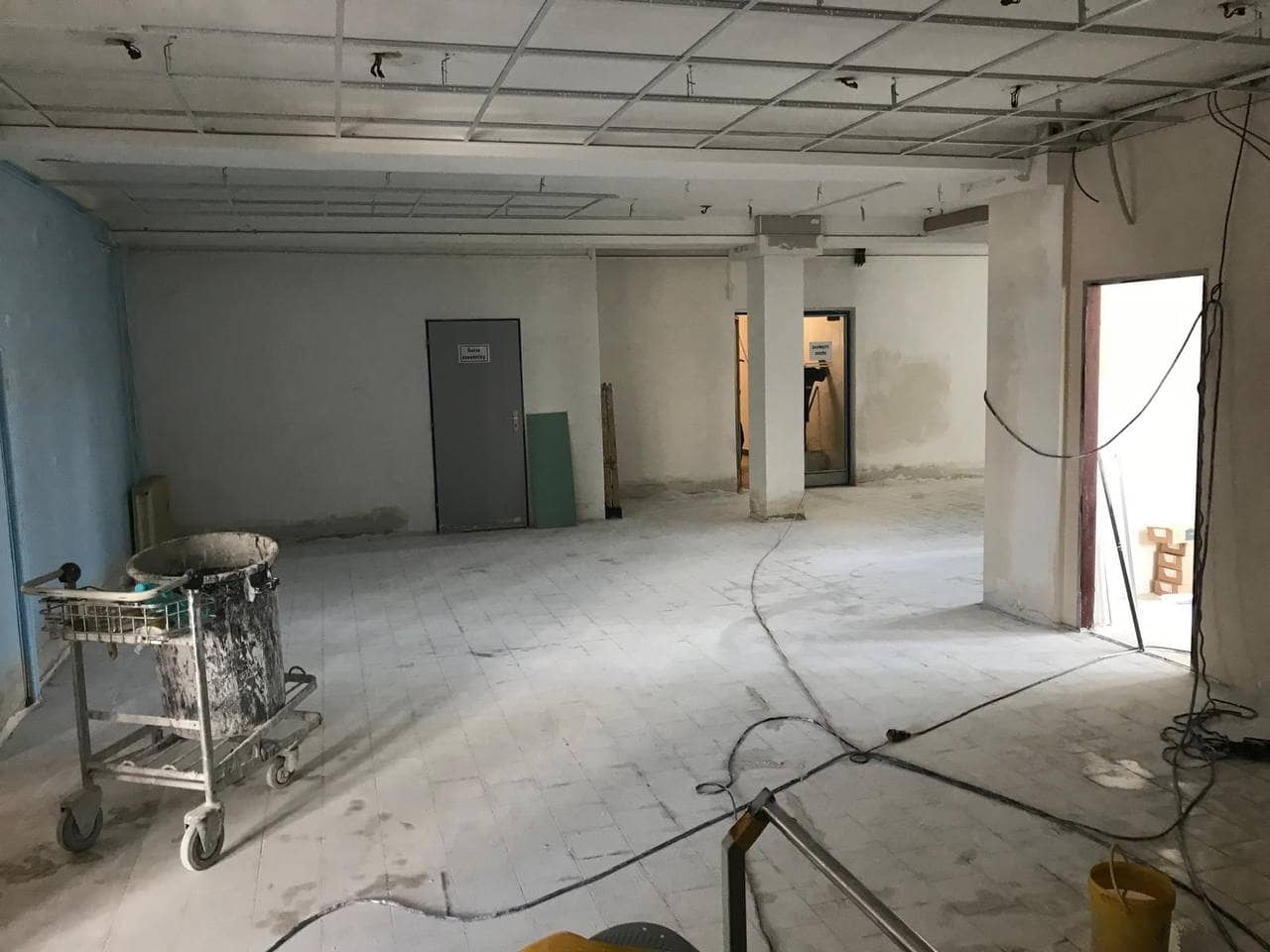 Obchodní prostor před úklidem po stavbě, se stavebním prachem a sutí